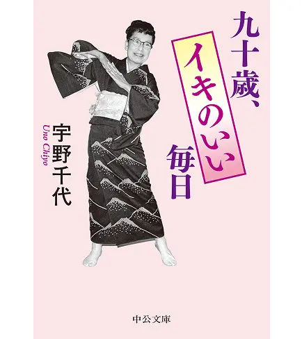 中公文庫『九十歳、イキのいい毎日 宇野千代』の表紙。淡いピンク色の背景に、粋な着物姿でポーズをとって楽しそうに微笑む宇野千代の全身モノクロ写真が配置されたブックカバー