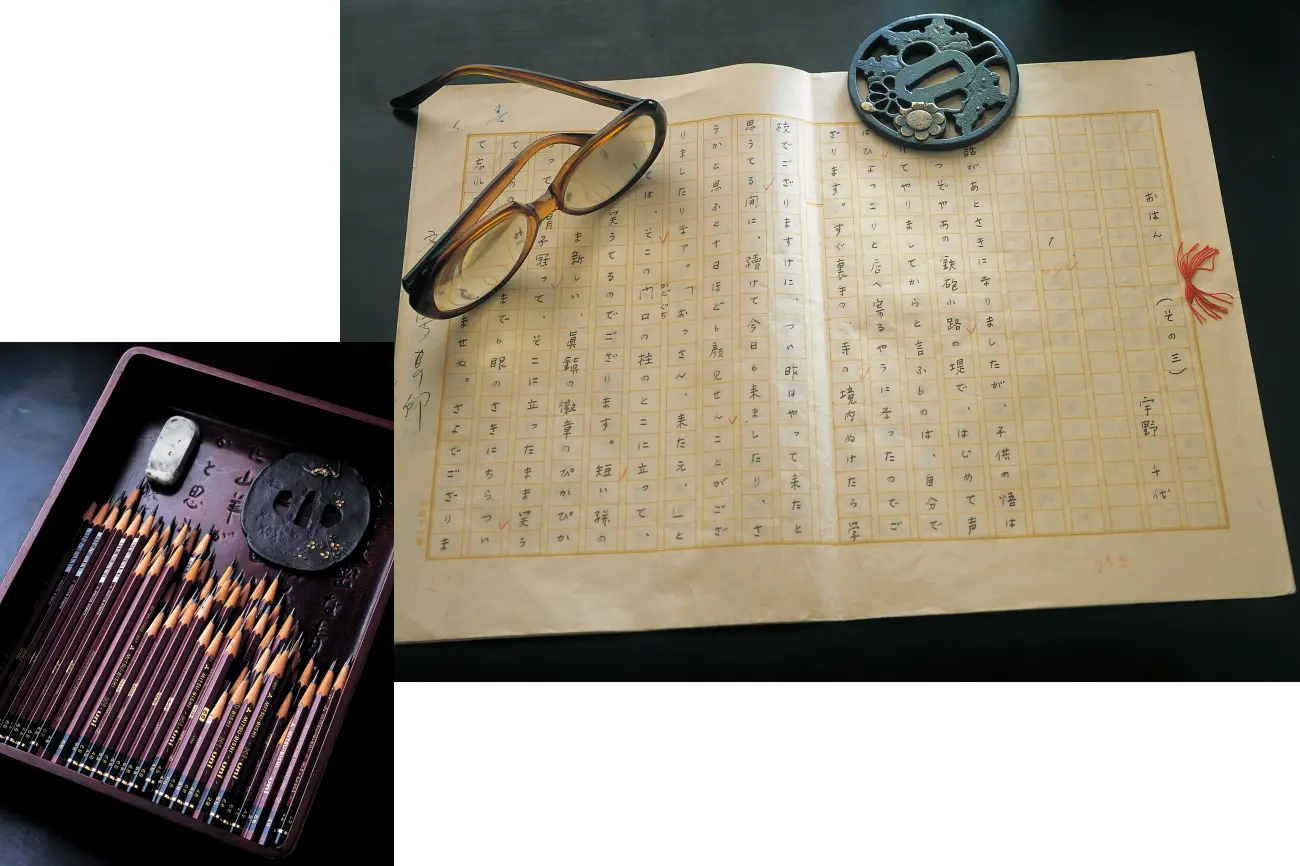 『おはん(その三)宇野千代』と書かれ推敲の跡が残る直筆の原稿用紙、その上に置かれた愛用の丸眼鏡と刀の鍔(つば)、そして左下にはお盆にきれいに並べられた大量の鉛筆と消しゴムを配置した、執筆風景を想起させる画像